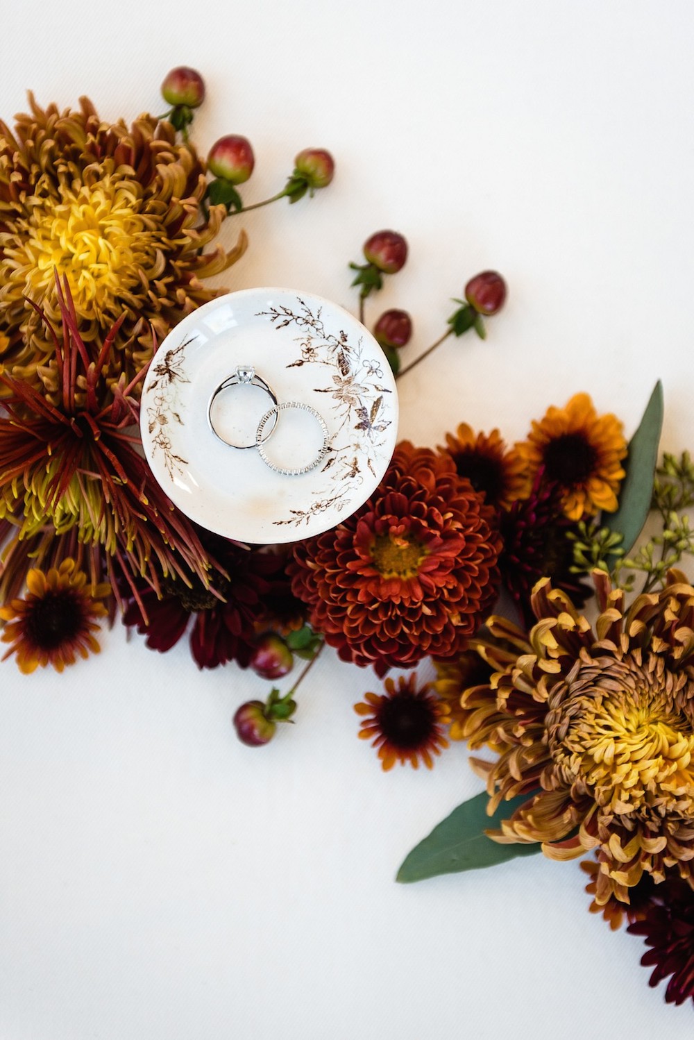 rings in ring dish with flowers in a flat lay