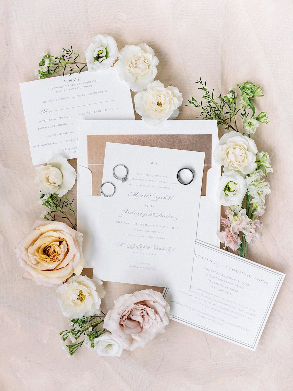 stationery surrounded by flowers and rings