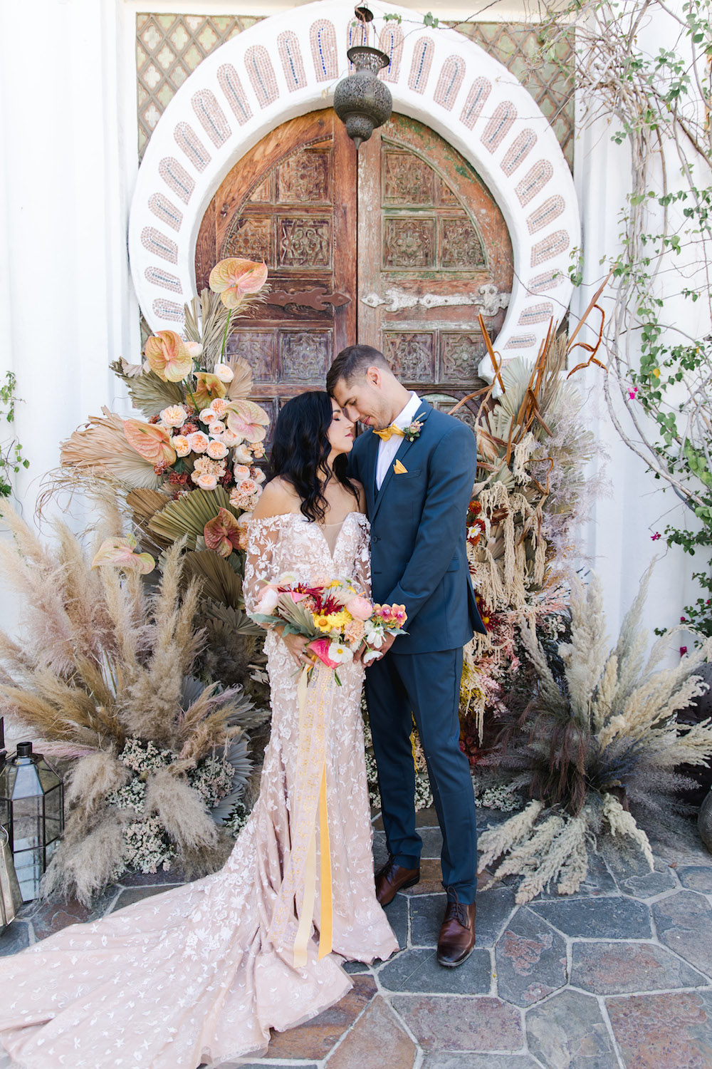 couple in front of pampas grass altar at wedding