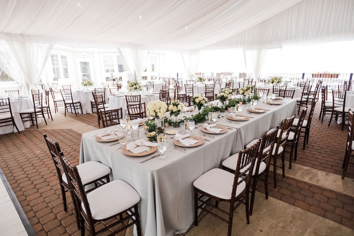 wedding reception set up underneath a tent with a tulle ceiling