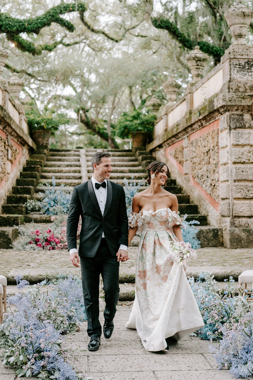couple walk back down aisle with colorful flowers