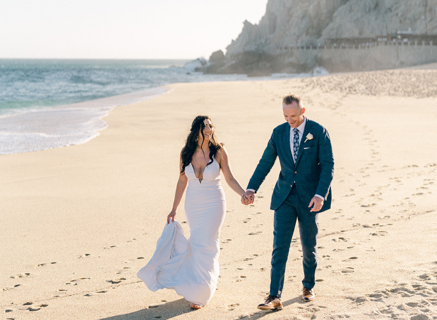 couple walk hand in hand on beach