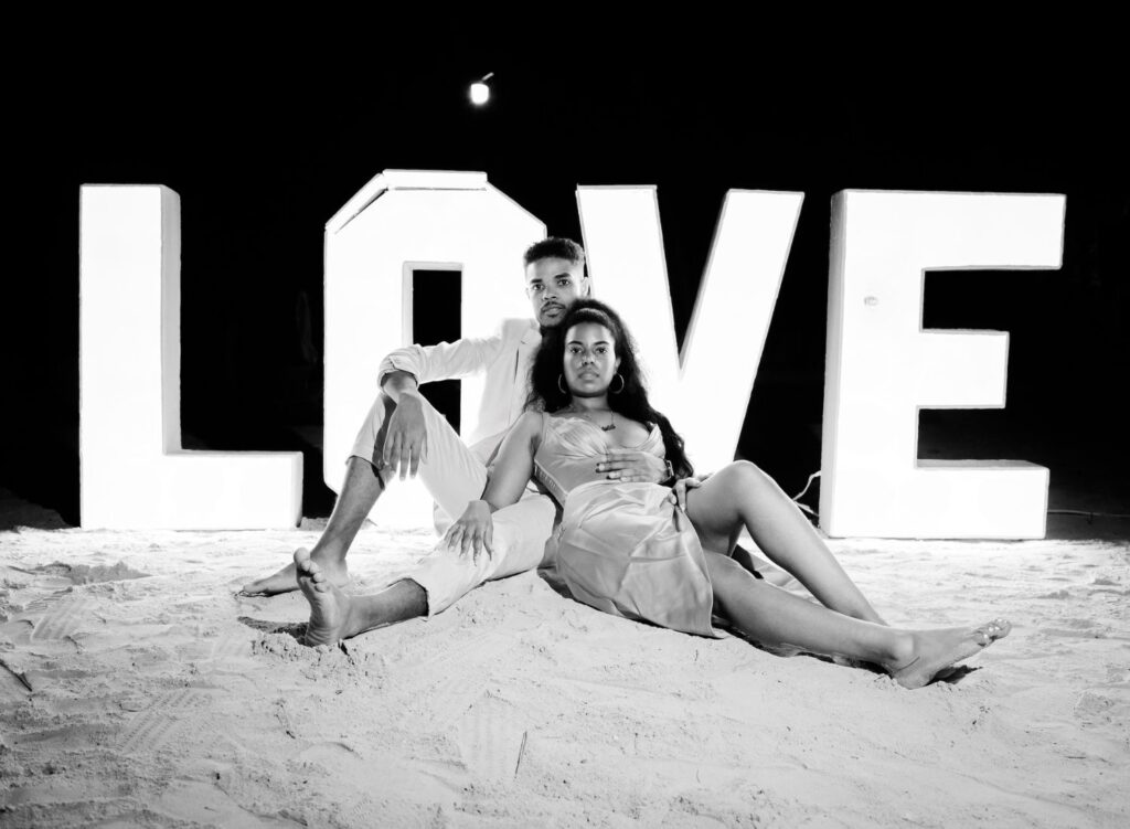couple posing by "LOVE" sign
