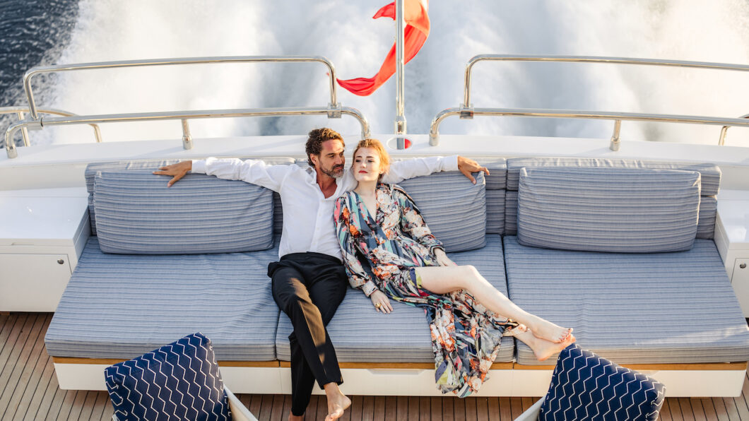 Couple sit on back of yacht