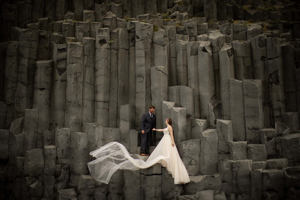 couple stand by black rock columns