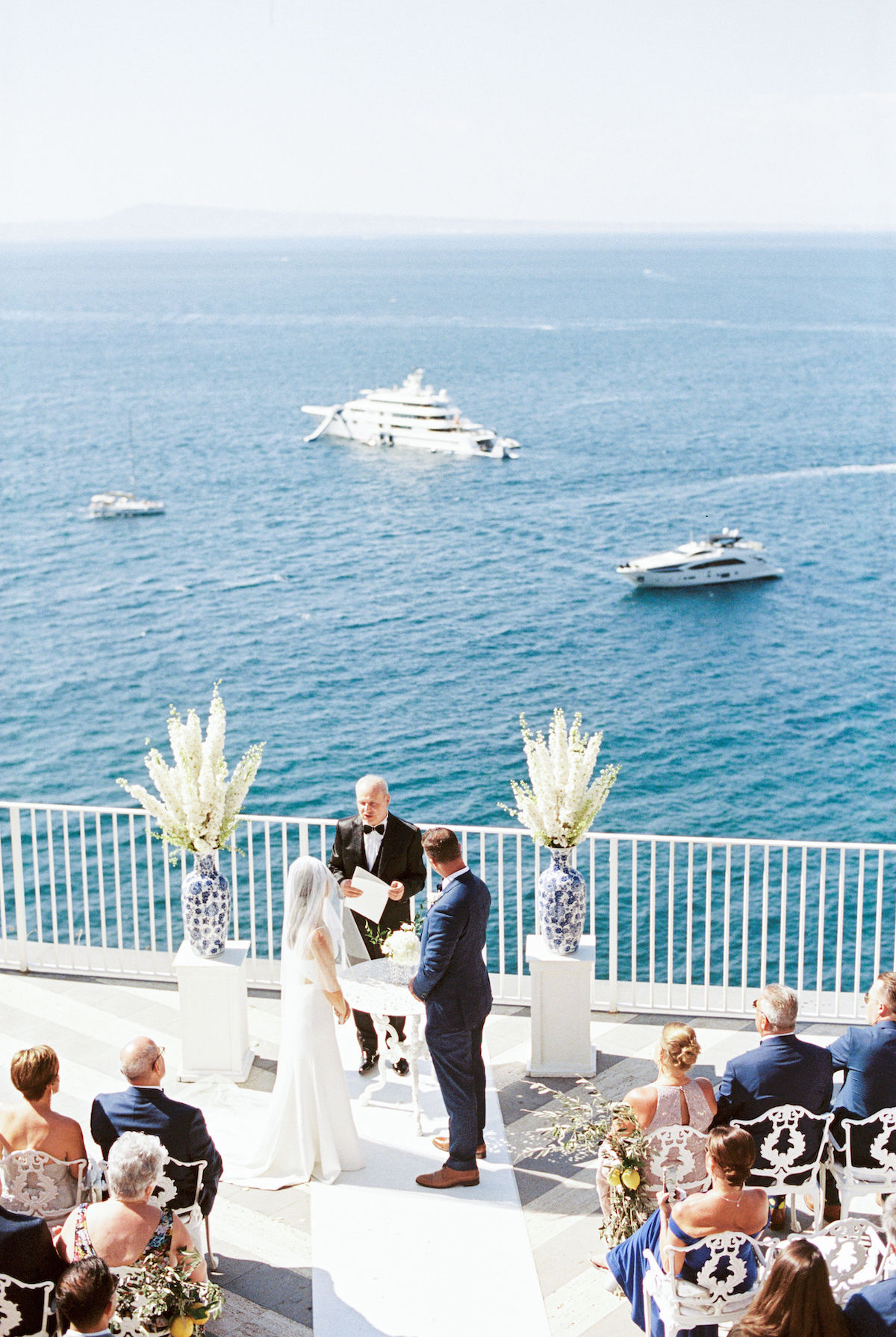 Bride and groom in wedding ceremony on terrace overlooking ocean