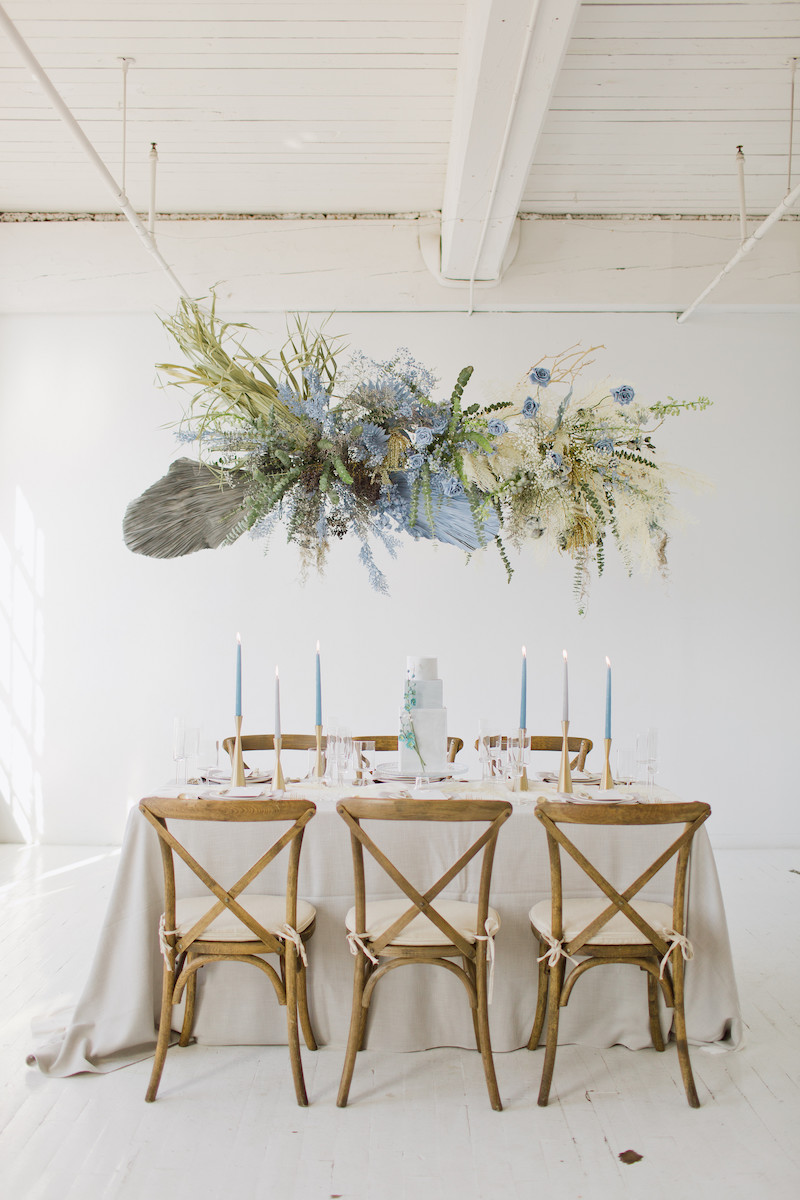 Wooden chairs accompanied by a white table and tapered blue candles