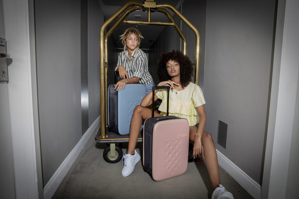 Models posing in luggage trolley with carry-ons