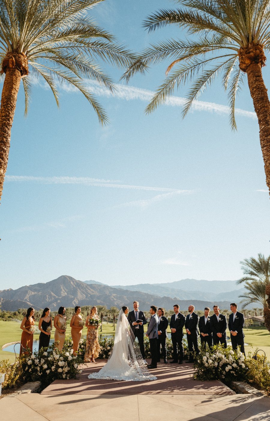 Outdoor wedding ceremony between two palm trees in Palm Desert, California