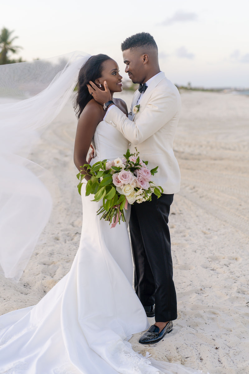 African American bride and groom posing on beach