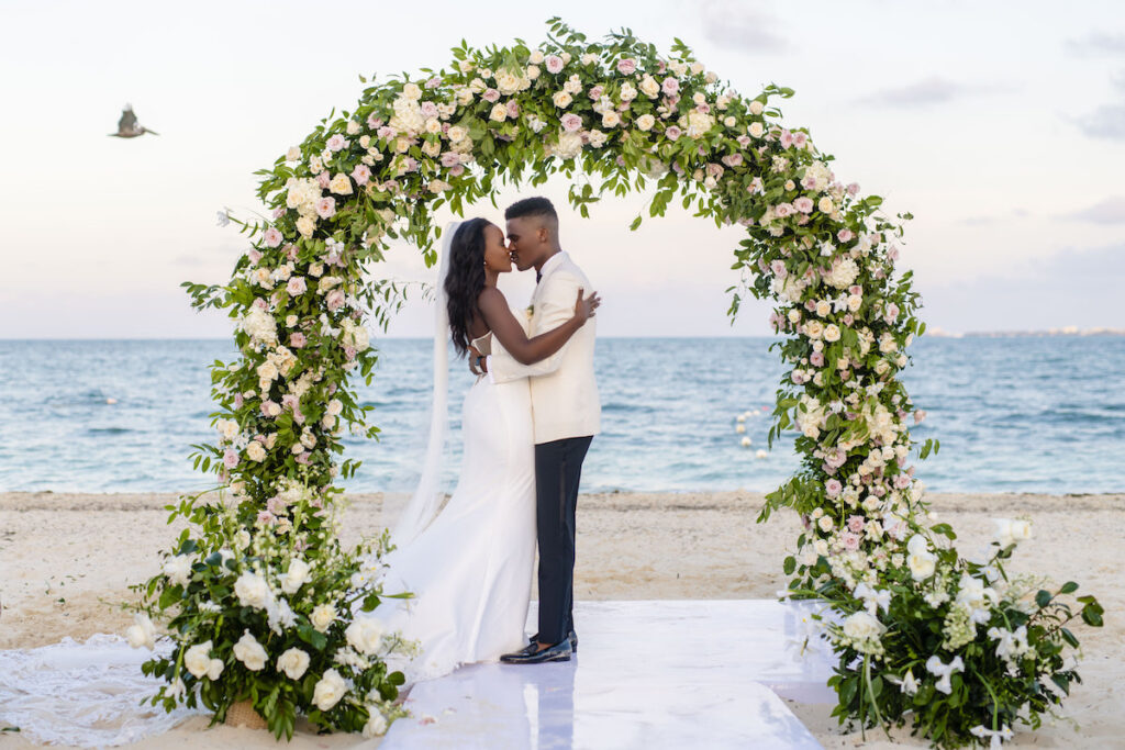 Couple under wedding arch on beach
