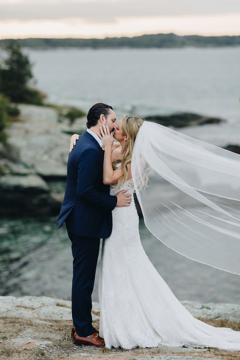 Bride and groom kissing near lake