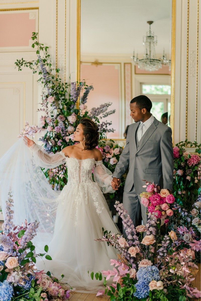 Bride and groom in hallway of florals.