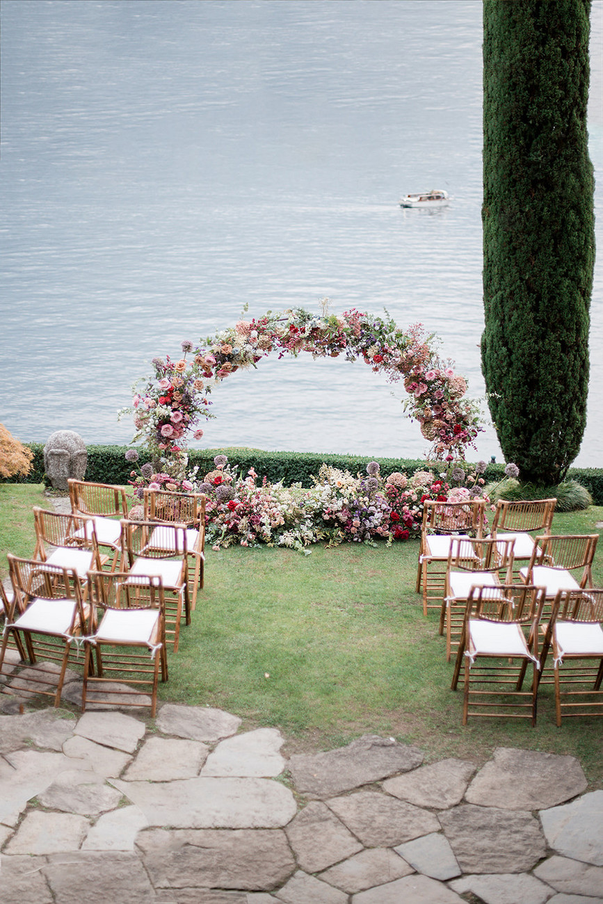 Lakeside wedding with bright flowers and wedding arch