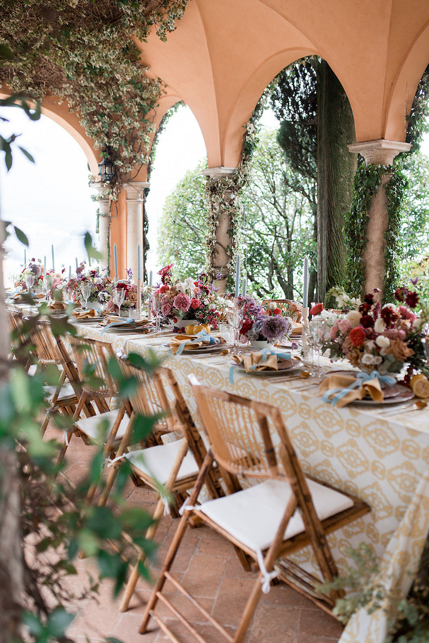 Dinner reception for a wedding with floral centerpieces on patio of Italian villa