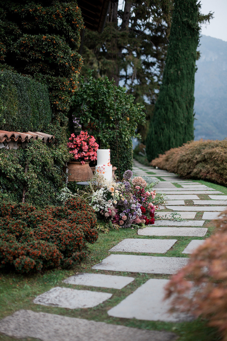 Wedding cake among florals in a garden in Italy