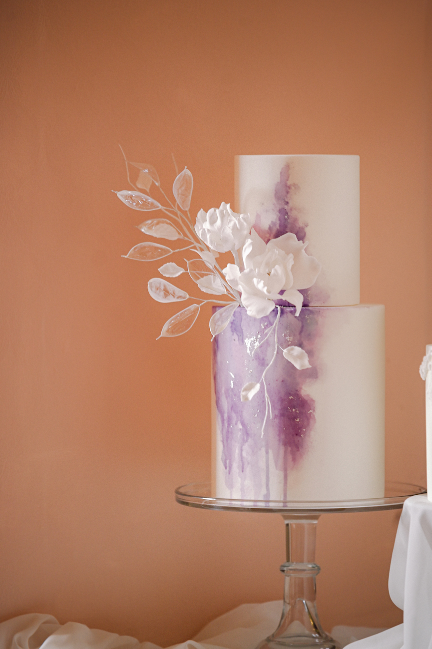 two tier cake with purple "smoke" effect and white flowers