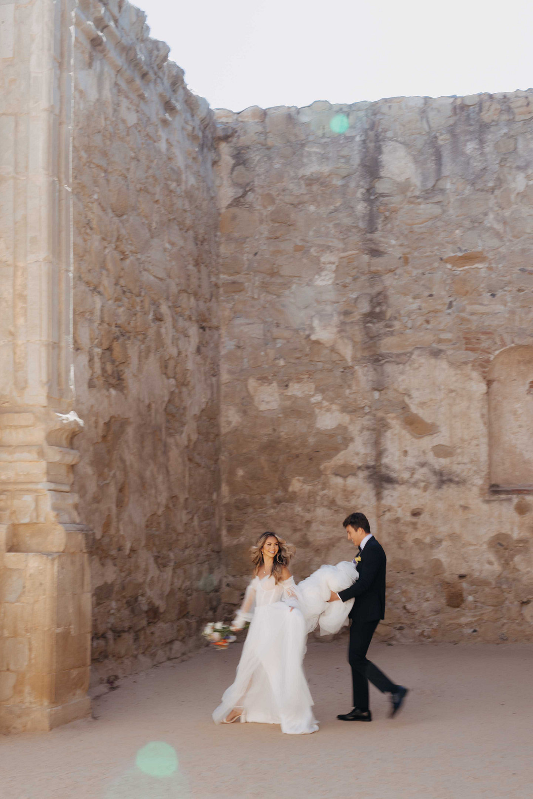 Modern bride and groom among high castle walls