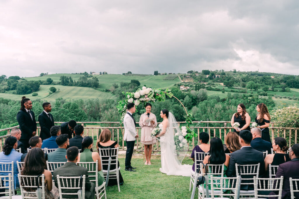 couple stand at altar with Italy's vineyards behind