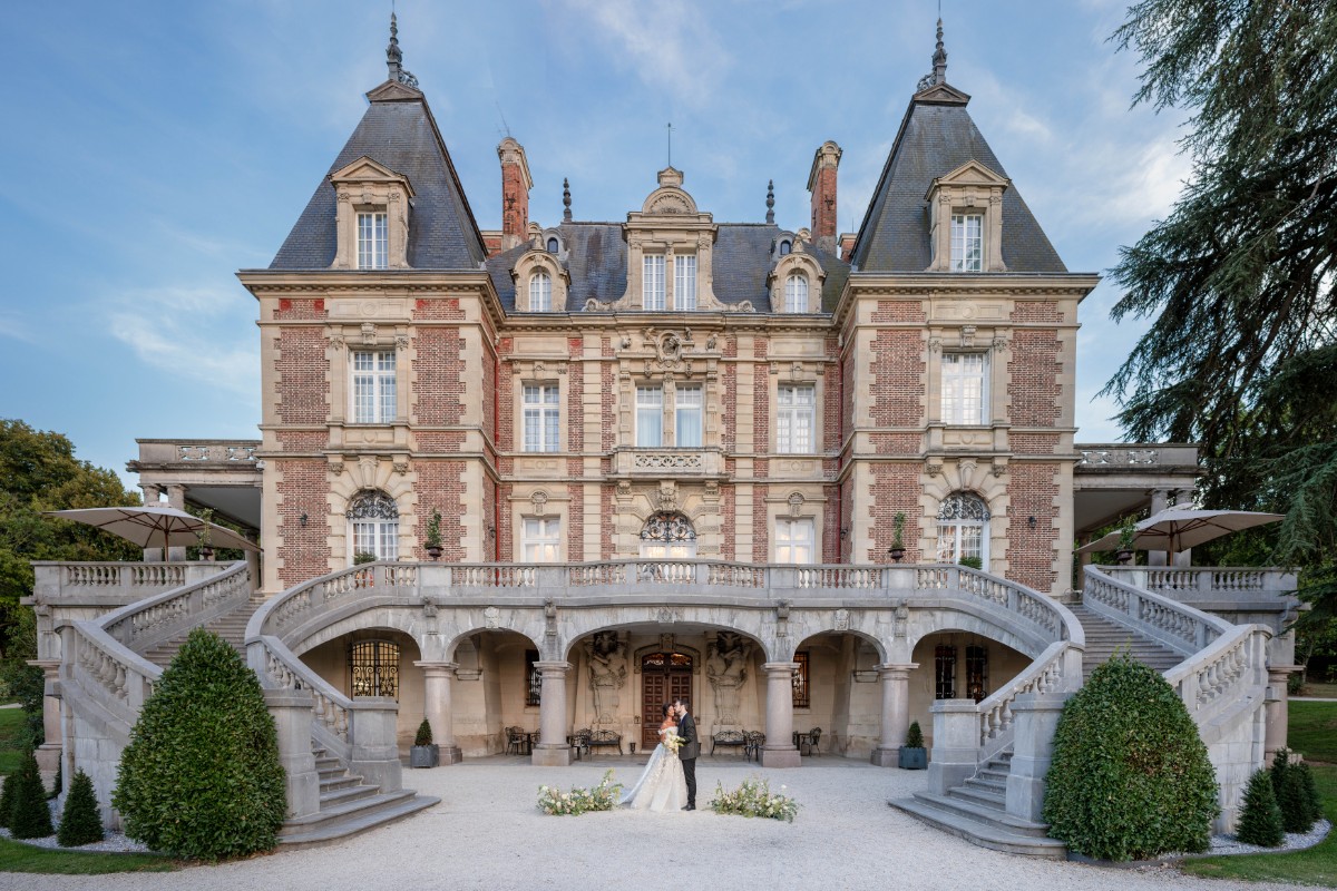 Wedding couple posing in front of French Chateau
