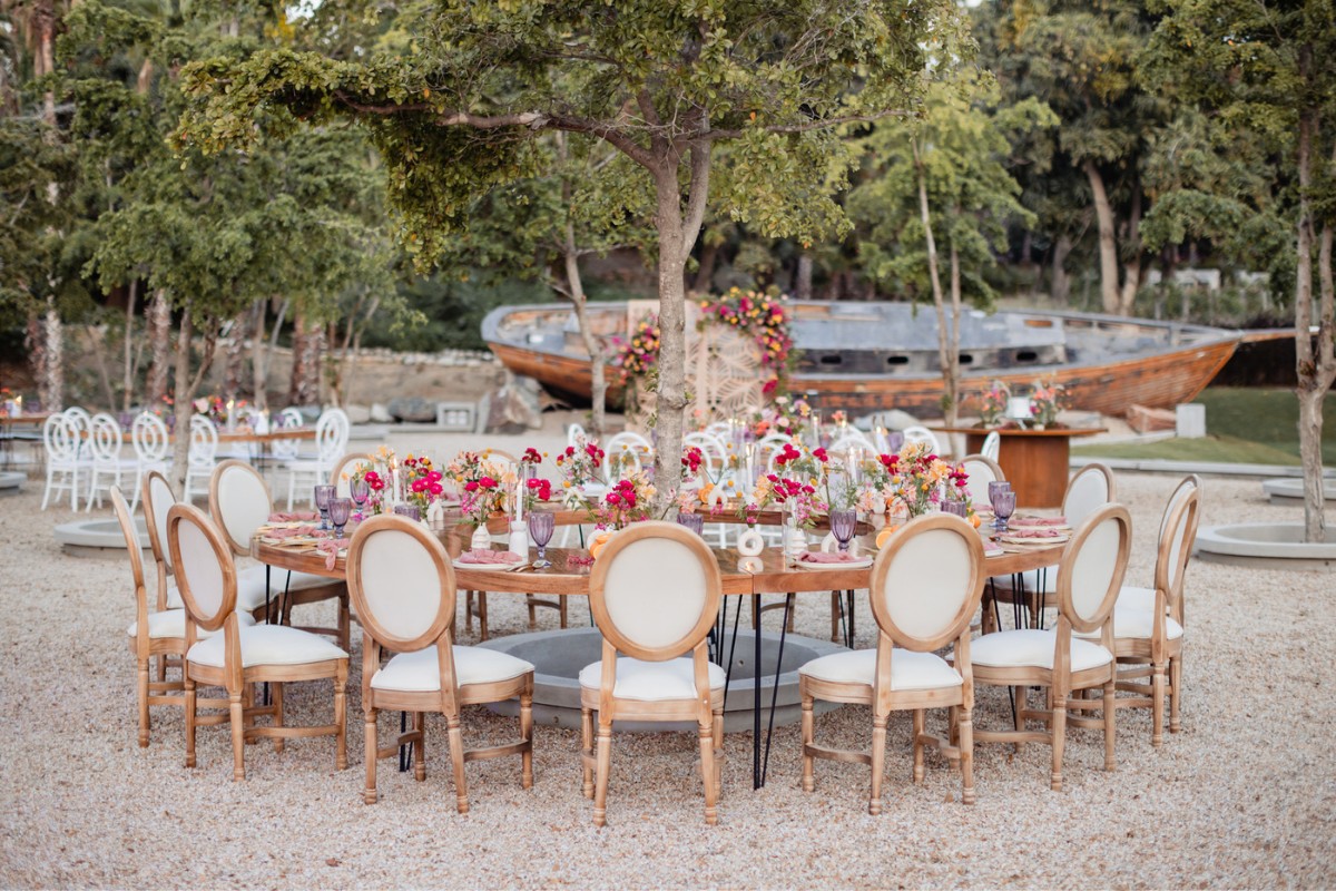 round reception table set around a tree on a beach