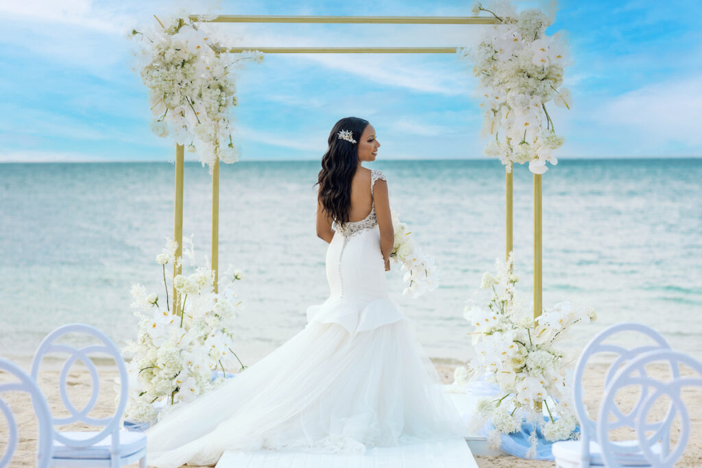 bride with white florals on beach