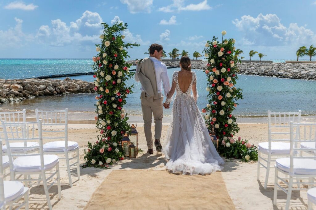 couple standing between two floral pillars