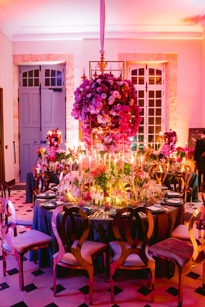 lavish table setting with gold chairs and pink centerpiece florals