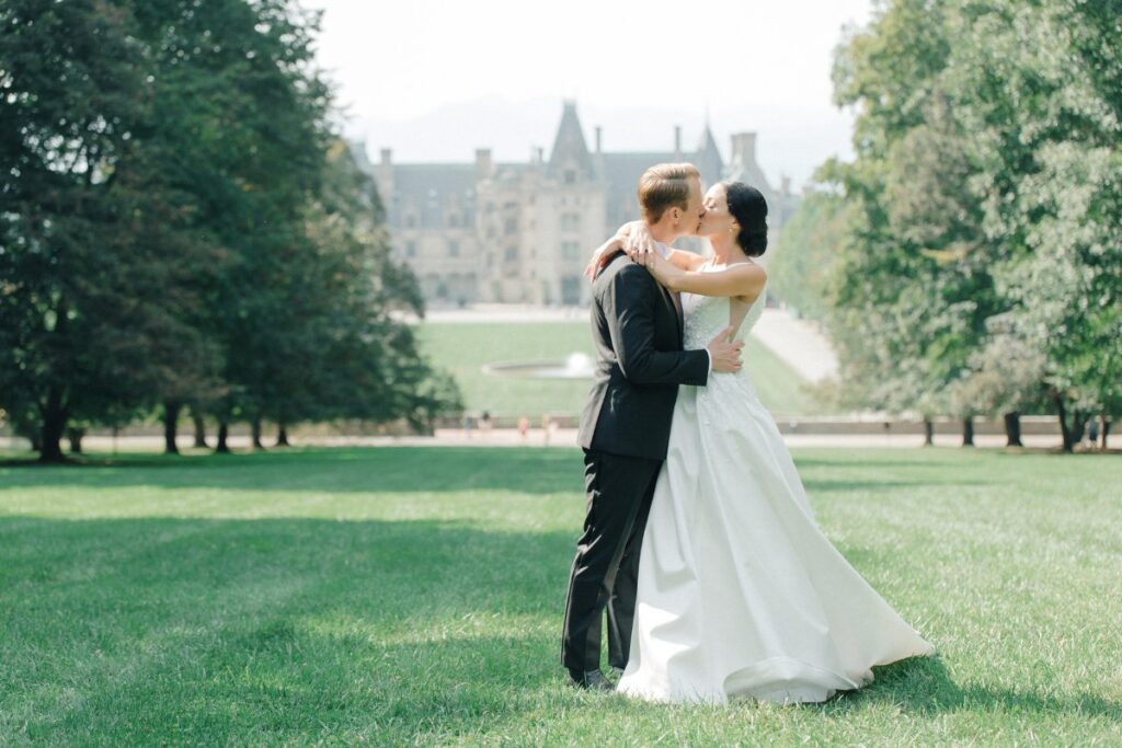 bride and groom kiss on lawn of Biltmore Asheville