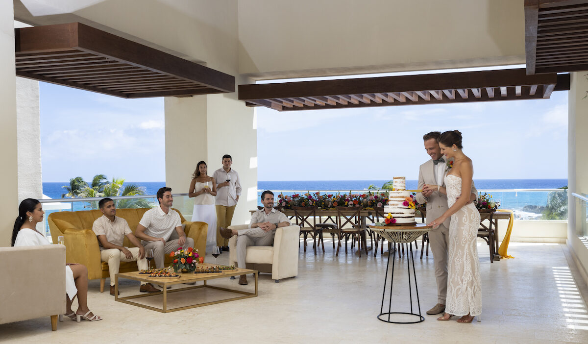 couple cutting wedding cake in Sky Terrace reception venue with ocean views