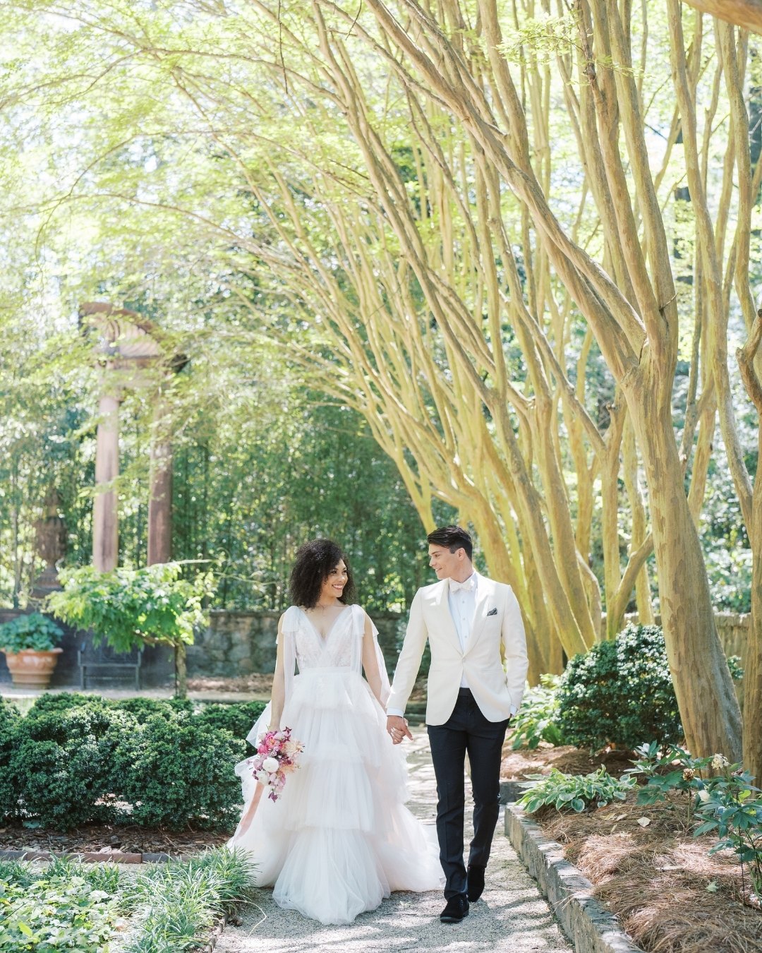 Bride and groom strolling in a garden hand in hand
