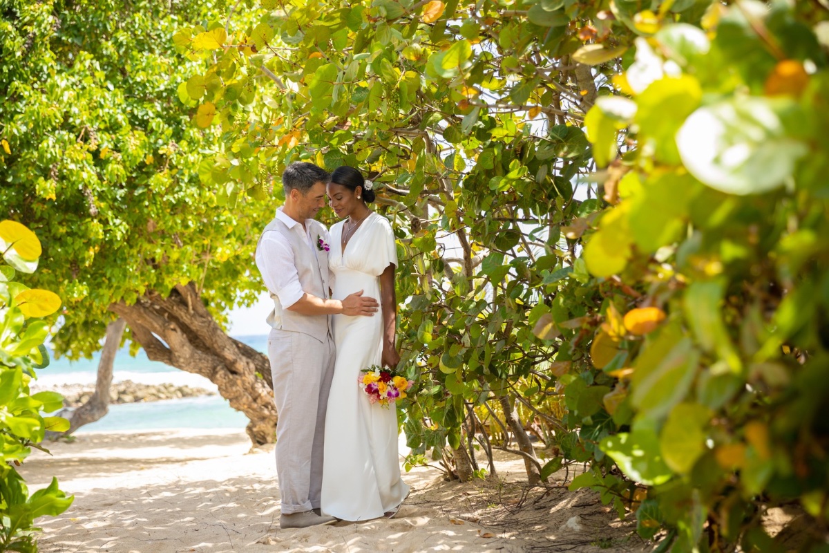 Couple stand on beach, surrounded by mangroves