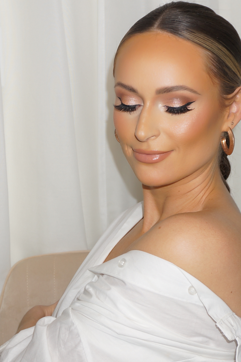 bride in white button down closing eyes with glam makeup