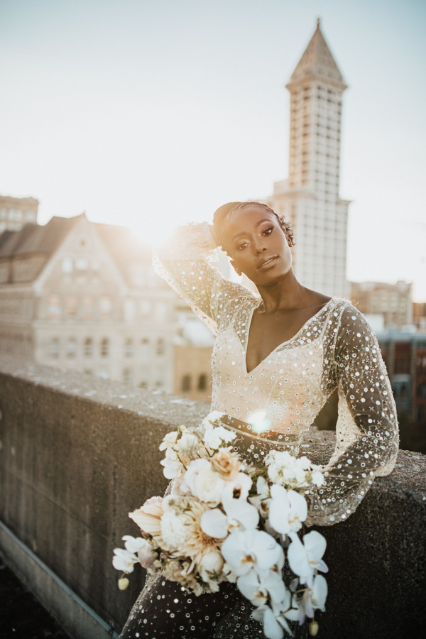 bride standing on a bridge holding a bouquet of flowers