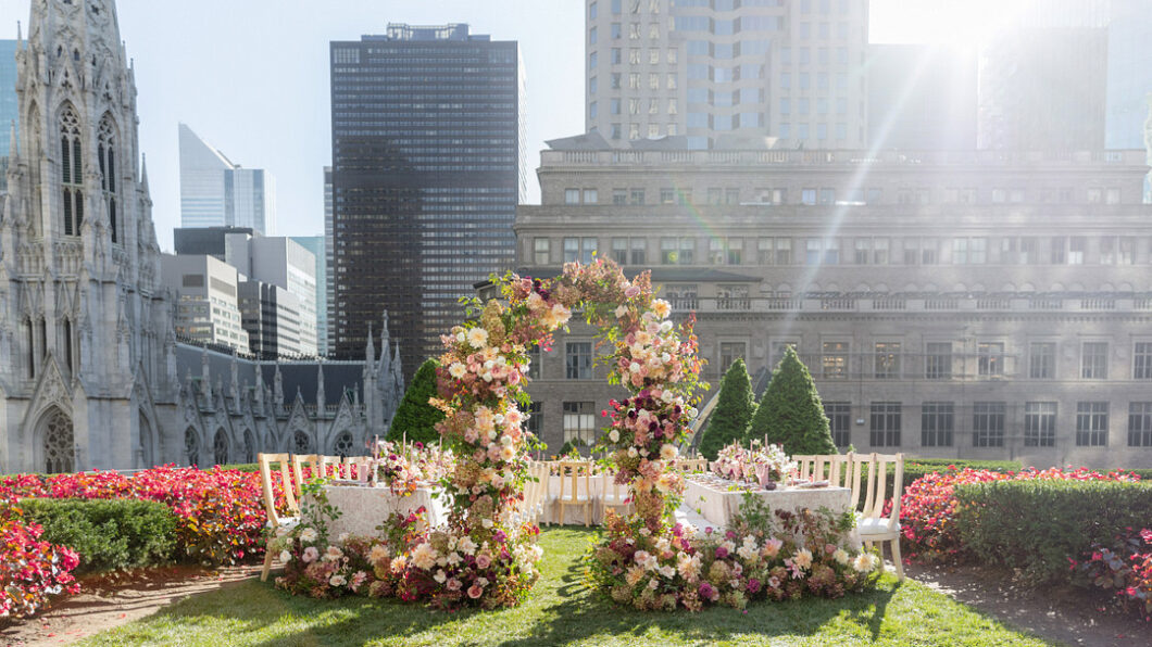 floral arch on a green rooftop overlooking New York city skyline