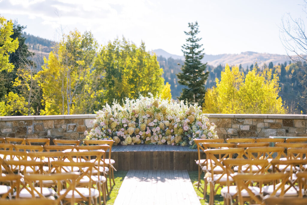 wedding ceremony setup with mountains in back and pink and yellow ground "altar" florals