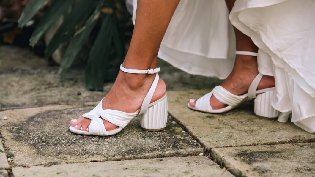 woman stepping in white heels with pleated silk charmeuse bridal accessories