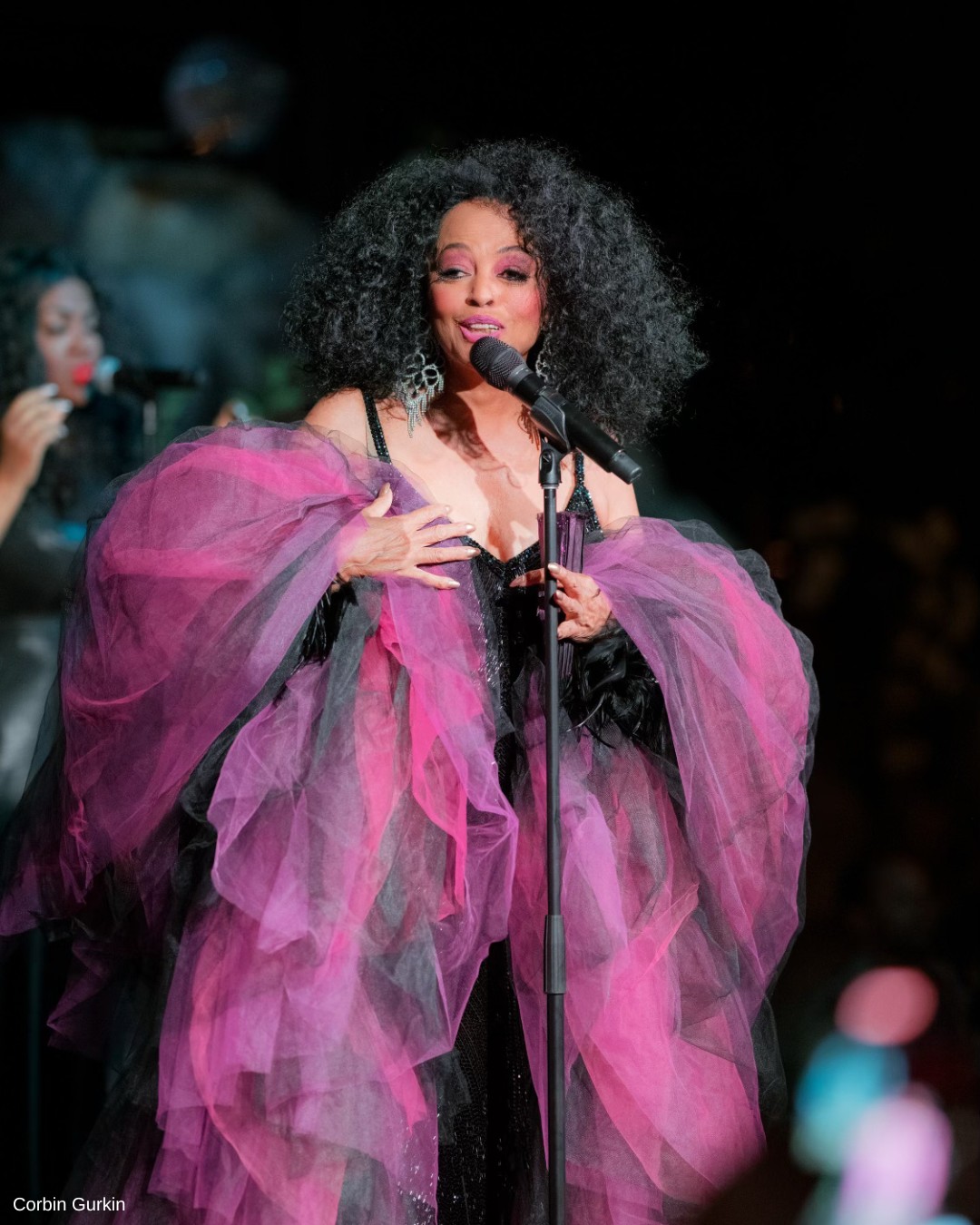 Diana Ross sings at Engage Summit wearing a shaw of purple, pink and black tule.