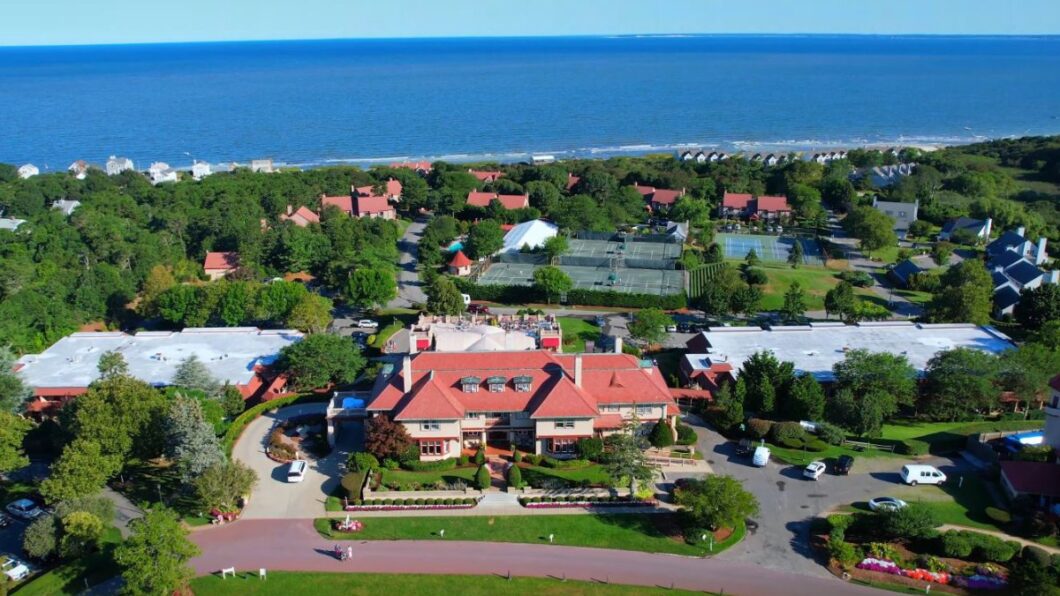 large building with red roof and ocean in backdrop