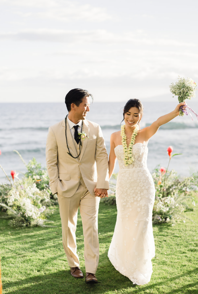 Maui weddings with bride holding bouquet up in the air