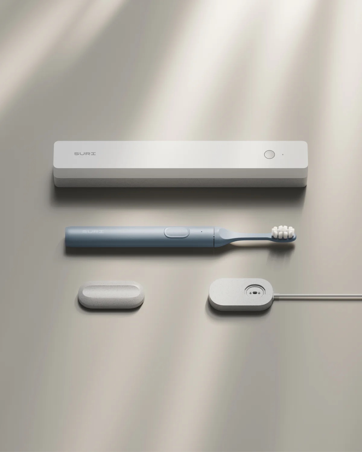 A sleek electric toothbrush set including a toothbrush, a charging case, a portable cap, and a wireless charging pad displayed on a neutral background.