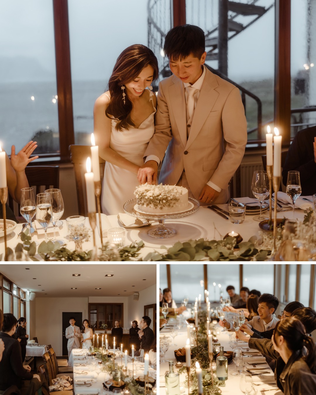 A couple cuts their wedding cake at a dining table adorned with candles and floral arrangements. Multiple guests are seated around the table, celebrating the occasion.