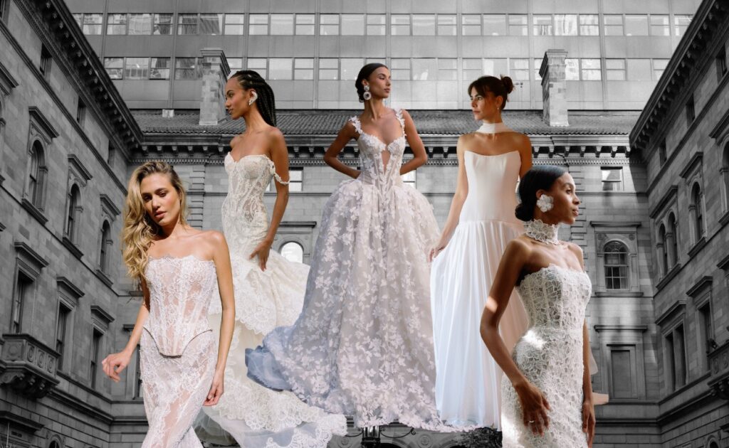 Five models in various bridal gowns stand in front of a historic building with large windows.