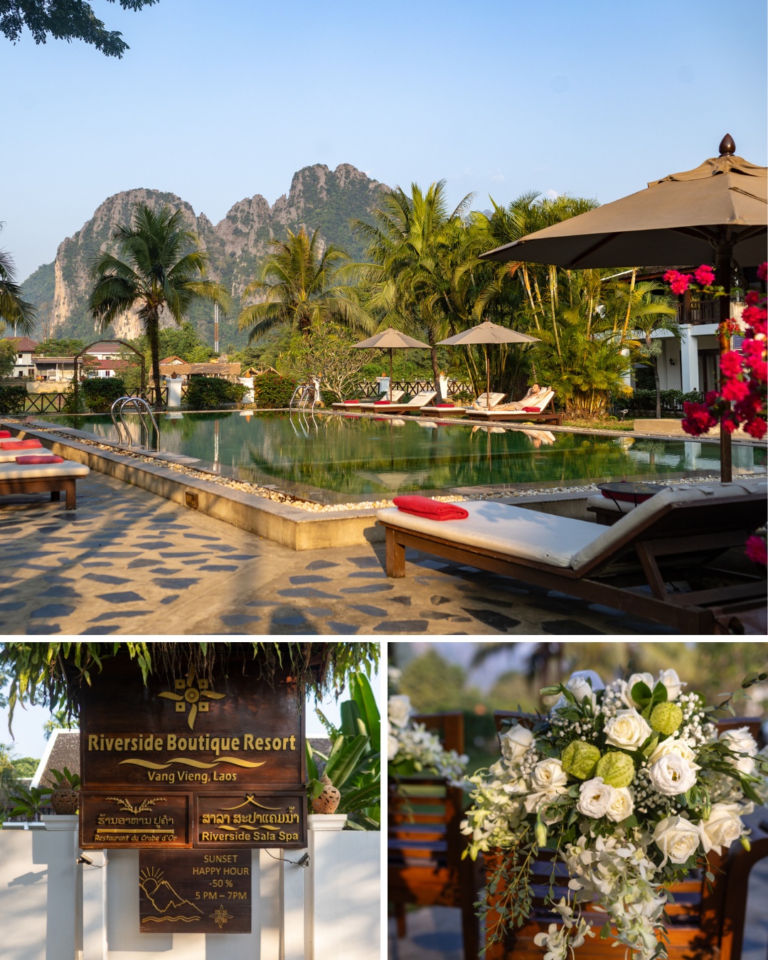 A tropical resort with a pool, lounge chairs, and umbrellas. A sign reads "Riverside Boutique Resort Vang Vieng Laos." Baskets of flowers are arranged decoratively near the sign. Mountains are in the background.