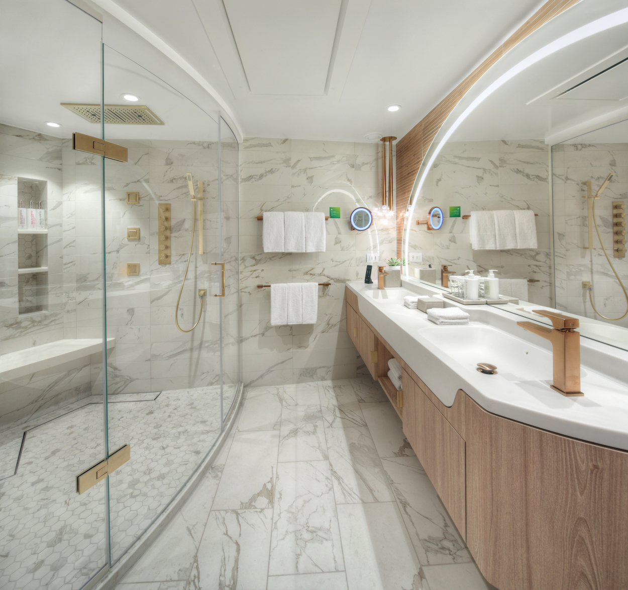 Modern bathroom with a large glass-enclosed shower, marble tiles, double vanity with illuminated mirrors, and wooden accents.