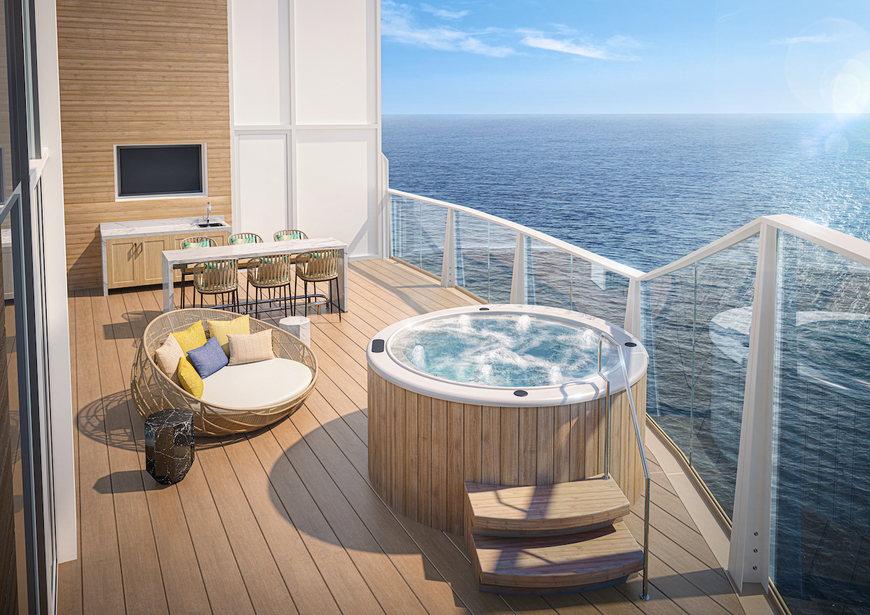 A luxurious seaside balcony features a hot tub, round seating area, dining table with chairs, and glass railing, overlooking a calm blue ocean under a clear sky.