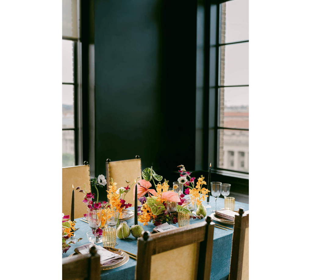 A table with flowers and plates on it.