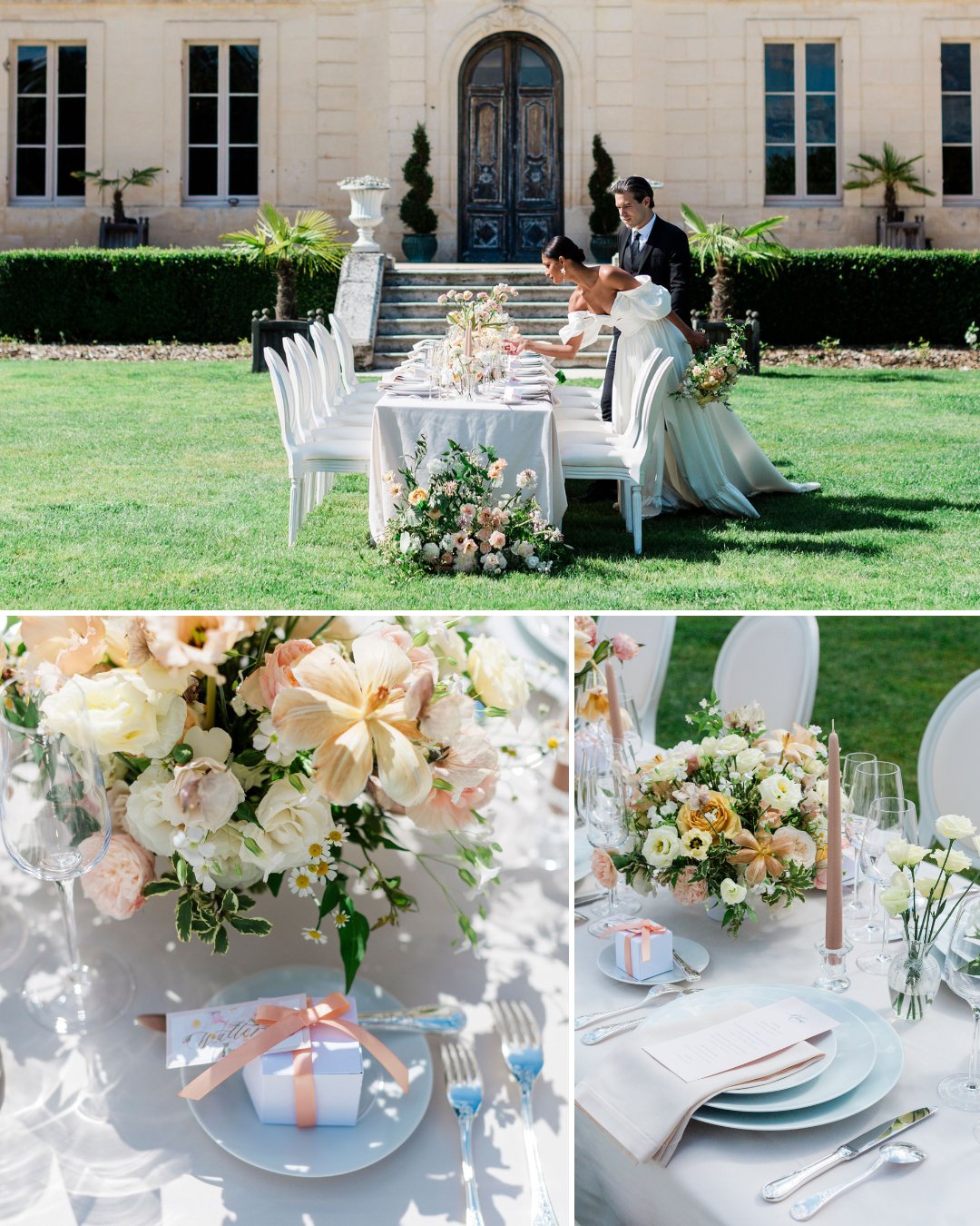 A bride and groom stand by an outdoor wedding table set with white chairs, pastel flowers, candles, and wrapped gifts in front of a large building.