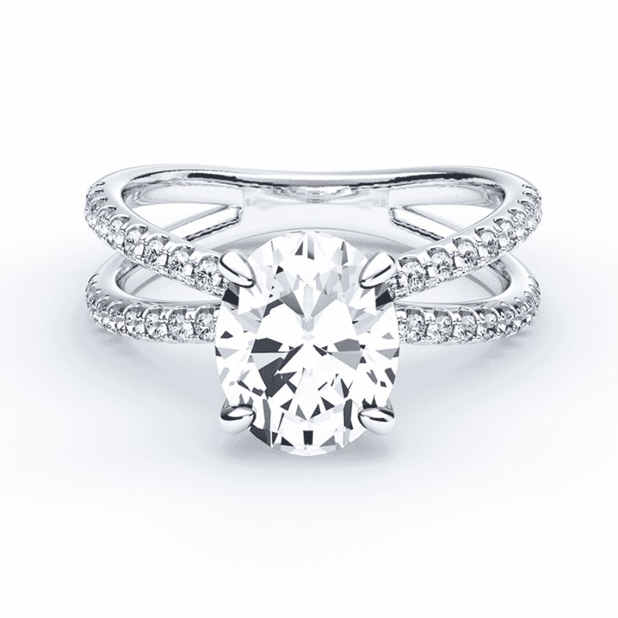 A silver ring with a large oval-cut center diamond and a split shank band encrusted with smaller diamonds.