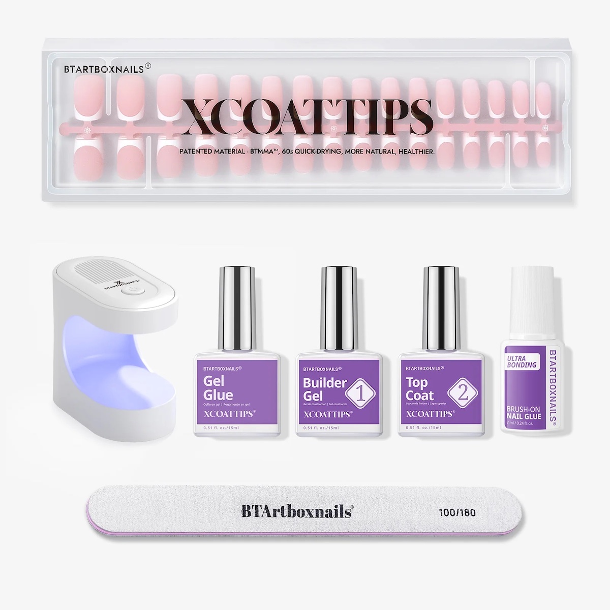 Nail extension kit with XCOATTIPS, gel glue, builder gel, top coat, UV lamp, nail file, and nail prep bottle, all arranged neatly on a white background.
